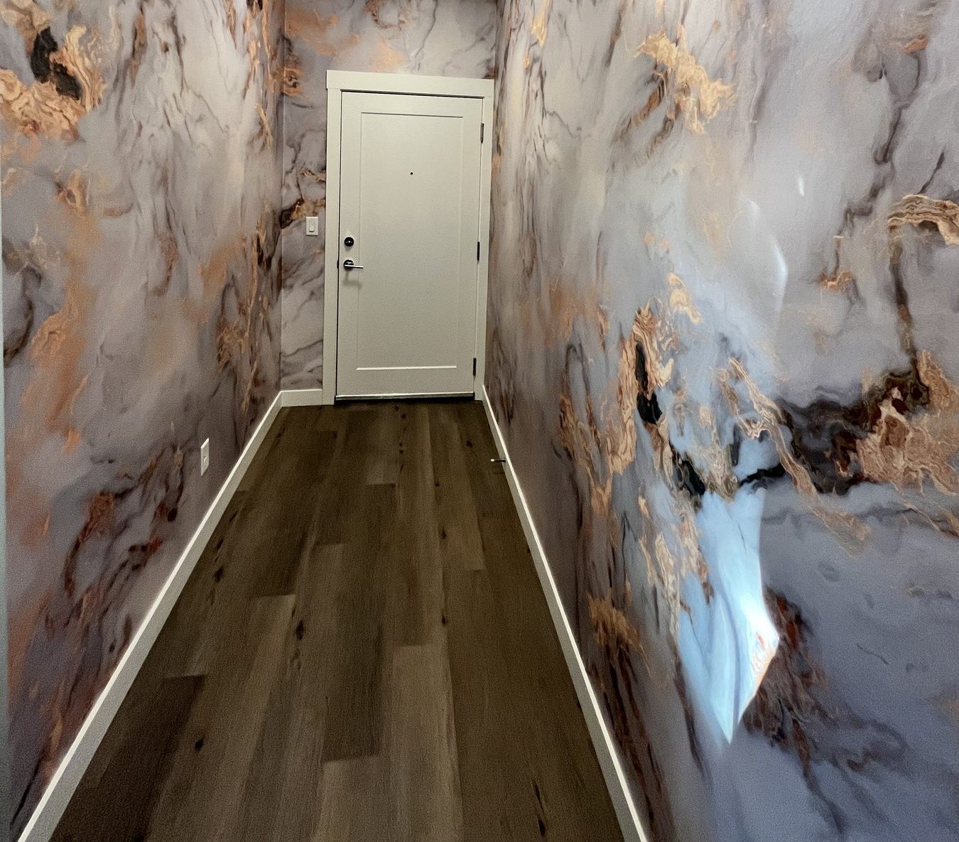 Marbled stone-look wallpaper installed in an entry hallway
