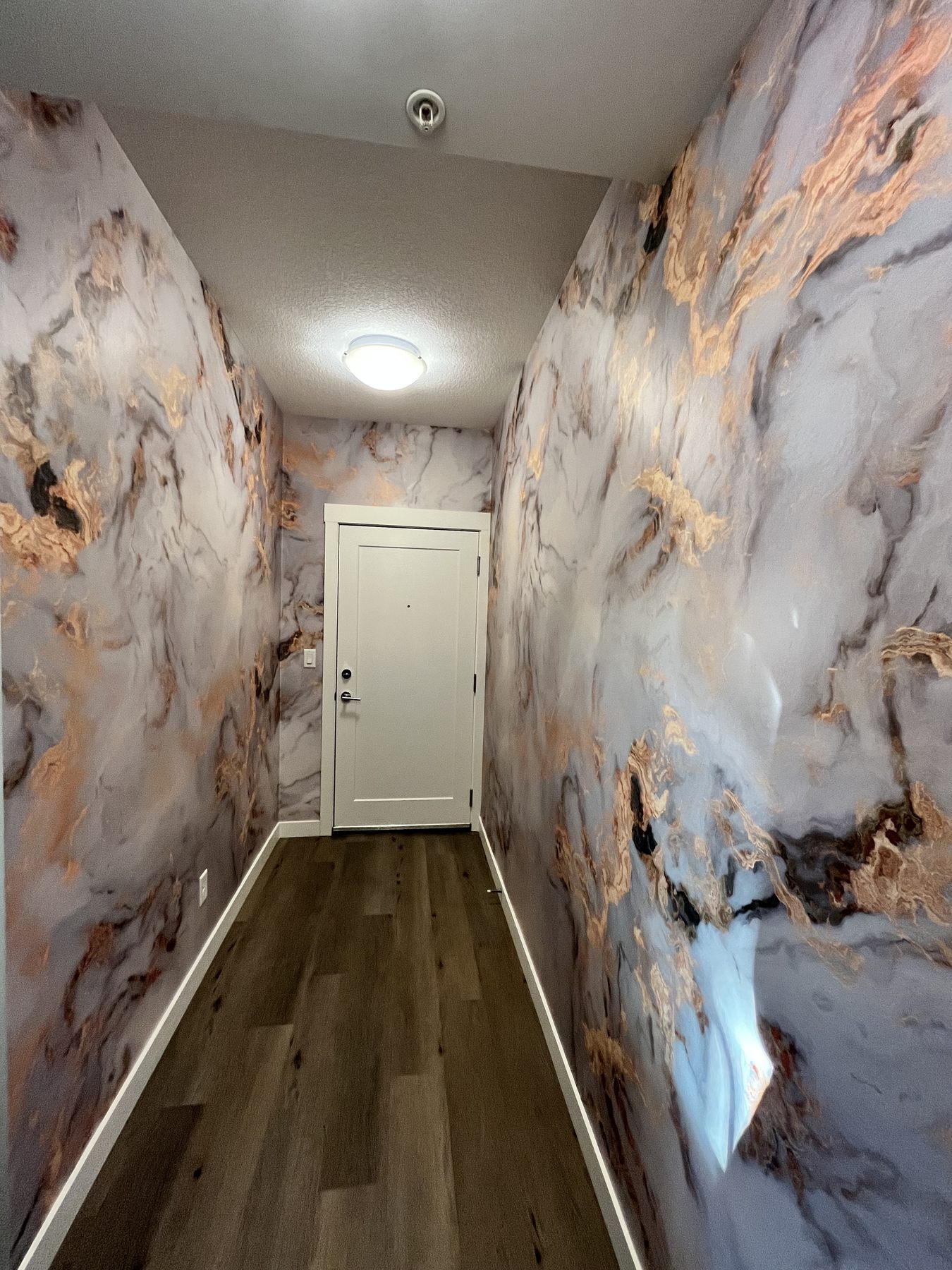 Marbled stone-look wallpaper in an entry hallway