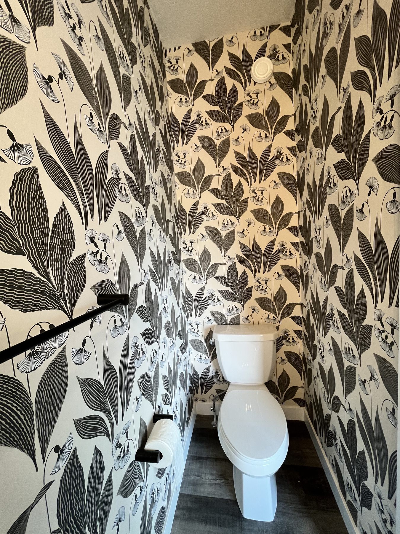 Powder room after black and white floral wallpaper installation