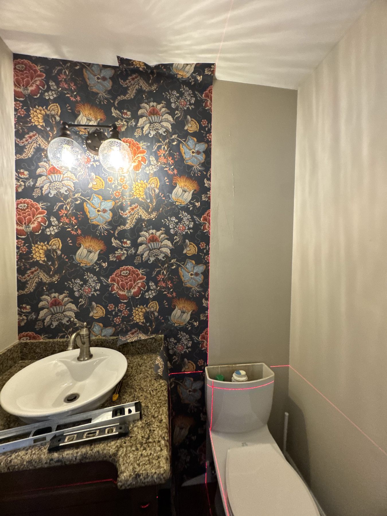 Powder room with dark floral wallpaper