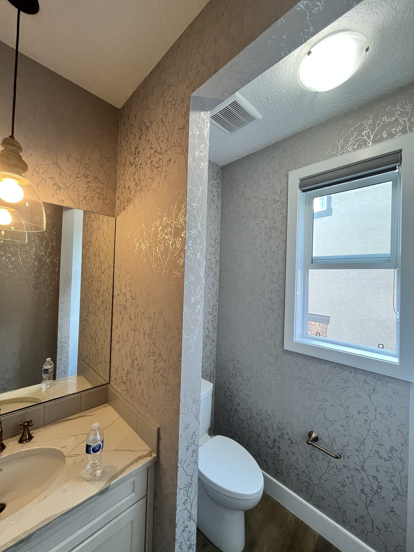 Bathroom vanity area with metallic floral wallpaper