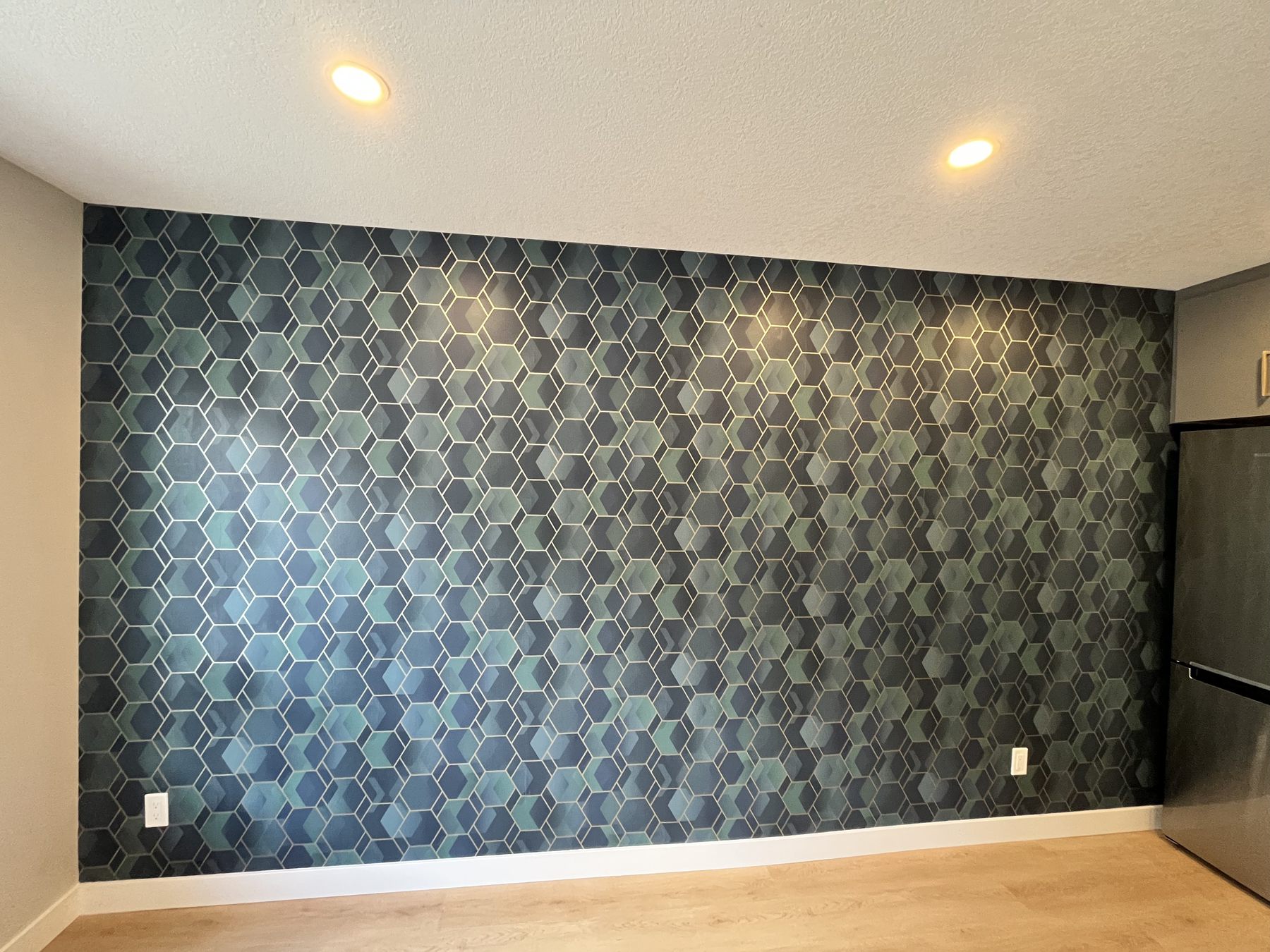 Bedroom accent wall after blue patterned wallpaper installation