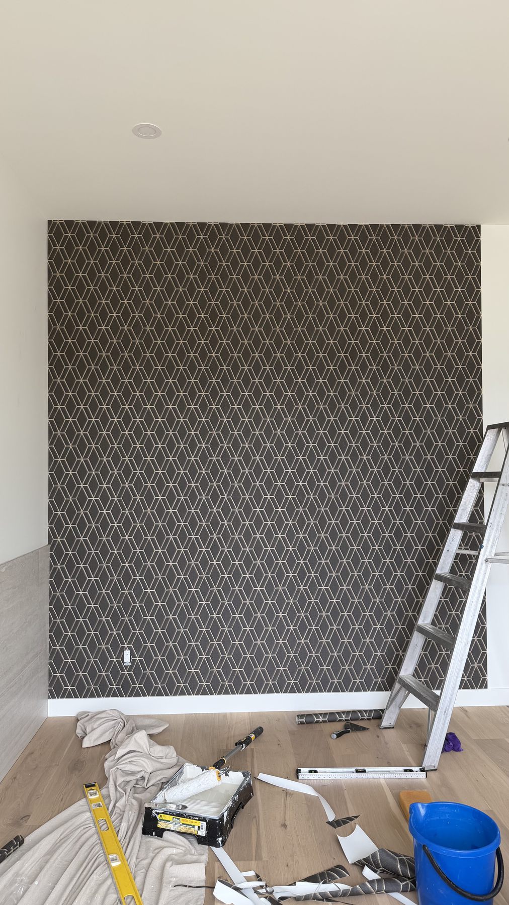 Wallpaper installation in progress with tools and materials