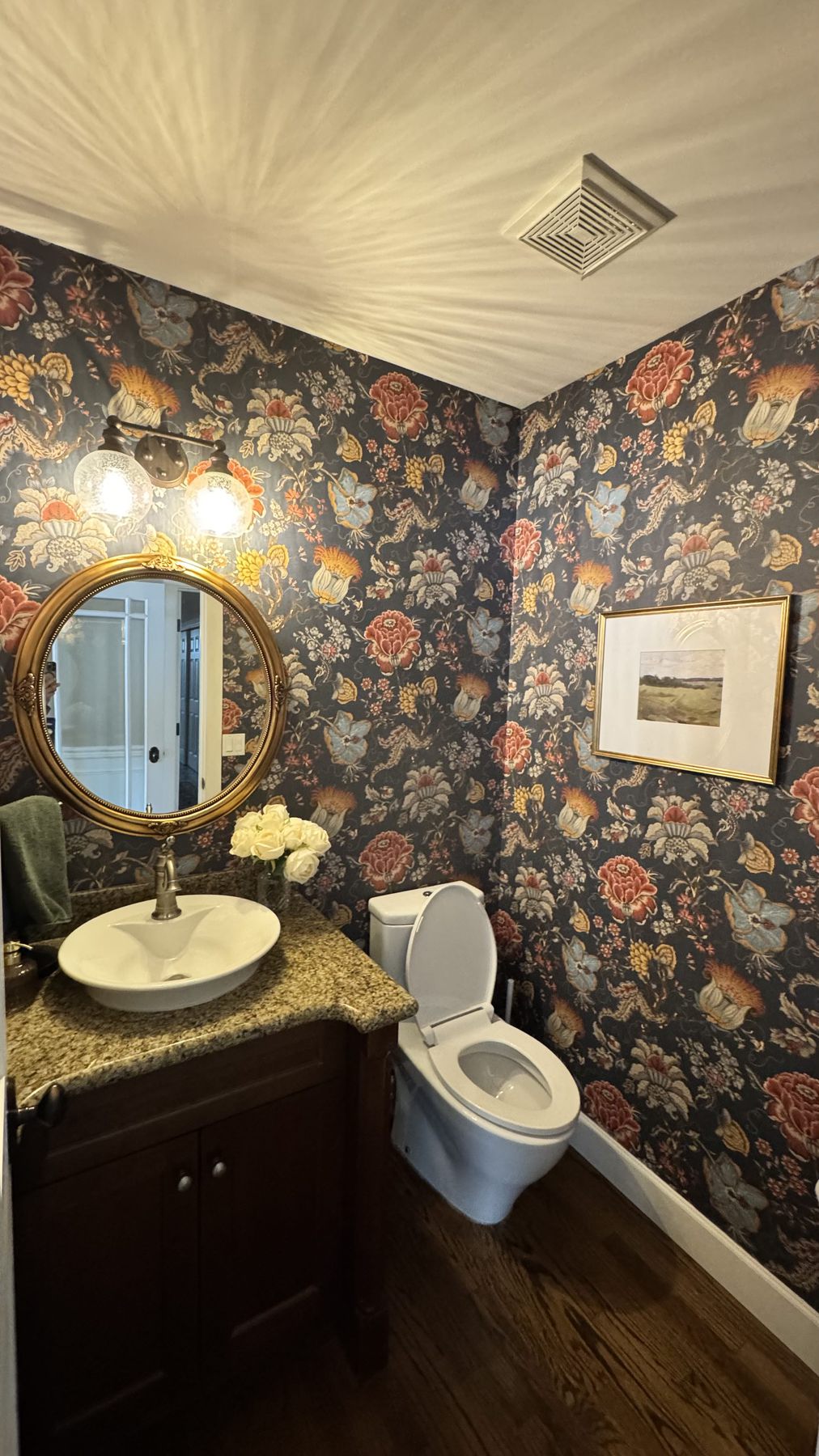 Bathroom finished with dark floral wallpaper