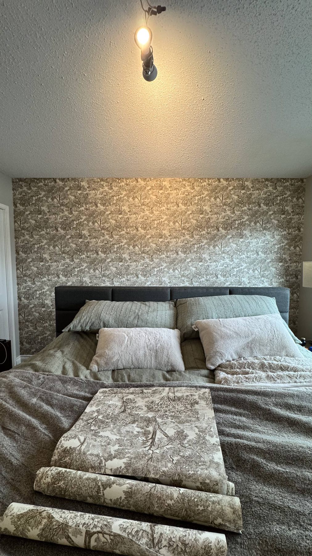 Textured wallpaper behind a bed headboard